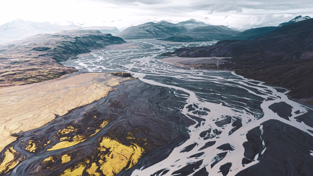 Vue aérienne des montagnes noires et blanches sous un ciel nuageux pendant la journée