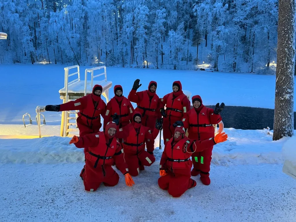 vue de personnes en combinaison grand froid qui vont flotter sur le lac gelé en finlande